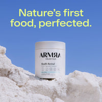 White ARMRA Colostrum Health Revival container with unflavored powder formula displayed on white textured surface against blu