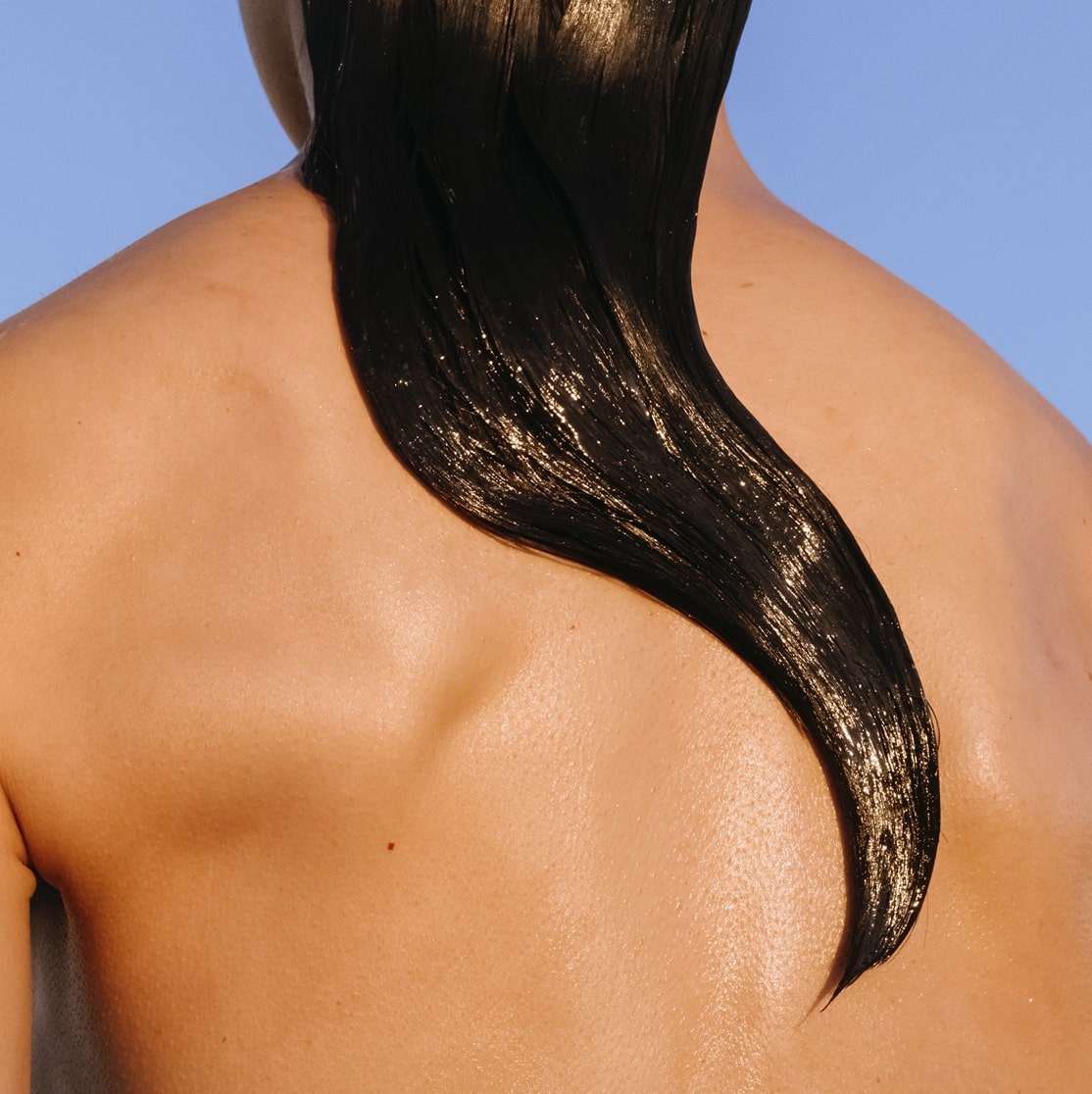 A woman with wet hair facing away from the camera
