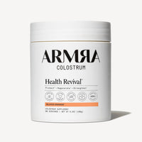 White cylindrical jar of ARMRA Colostrum powder in Blood Orange flavor, 6.3oz, with white lid and product labeling.