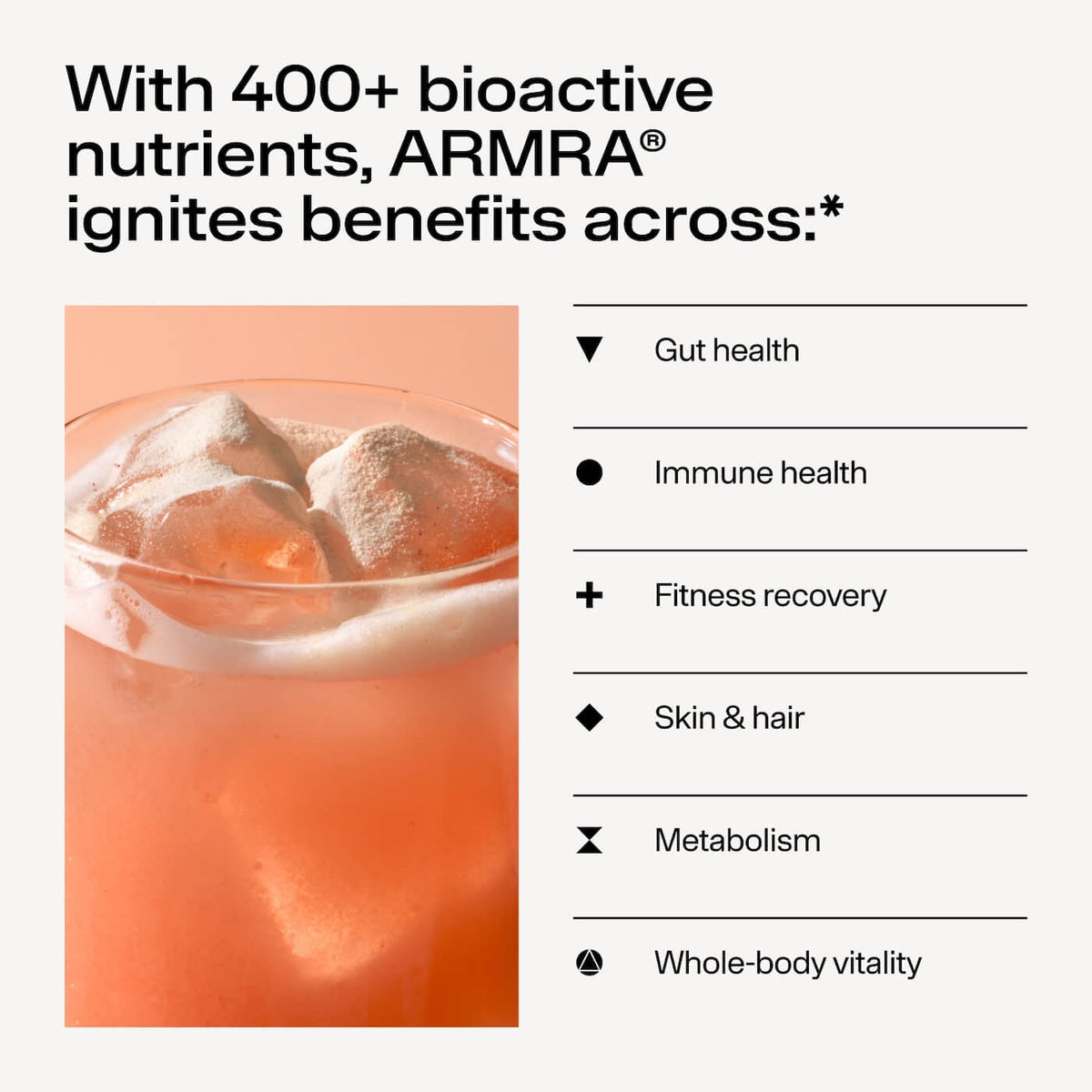 Glass filled with peach-persimmon colored beverage and ice cubes.