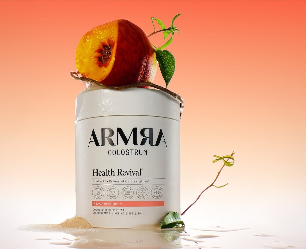 A Jar of ARMRA colostrum peach persimmon with a peach on top.