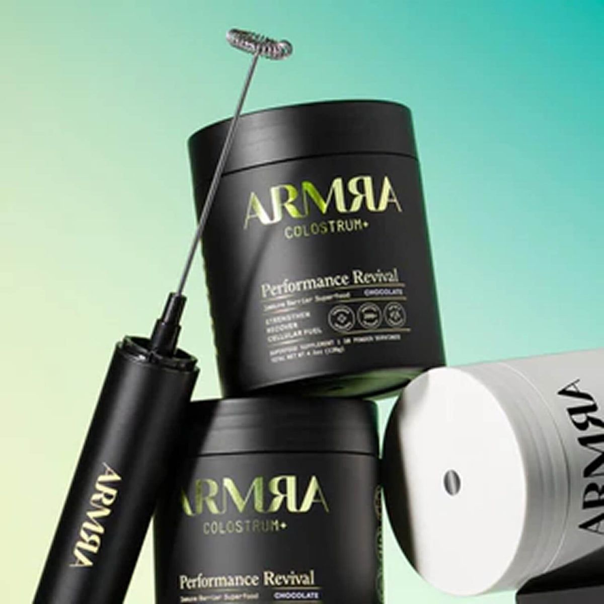 Black ARMRA Performance whirl tool with metal spiral head next to black and white product containers against turquoise backgr